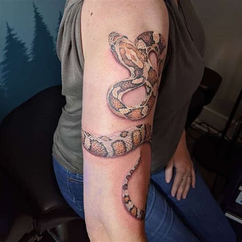 snake wrapped around arm tattoo.